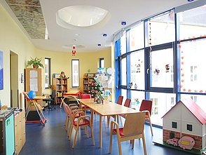Spielzimmer mit Tisch und Stühlen in der Kinderklinik Rostock.